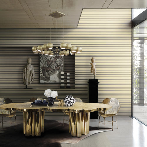 Golden dining table with wood structure in a well lit dining room. Golden striped Infinity wallcovering give the room extra depth. Artworks in black and white.