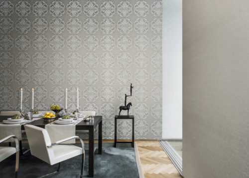 Salle à manger avec une table dressée, prête pour un délicieux dîner. Impressionnant revêtement mural damassé de la gamme Elegance. Piédestal avec une statue d'un homme debout sur les mains d'un homme, debout sur un cheval.