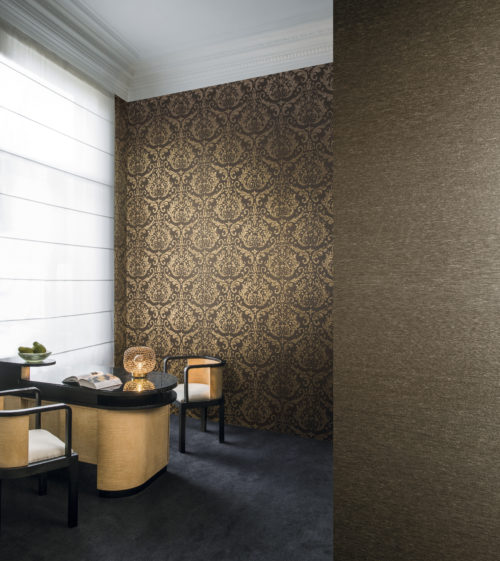 Pièce de style classique avec un bureau ou un bar et deux sièges. Deux revêtements muraux Omexco brun foncé sur les murs. Un damassé doré, un uni.