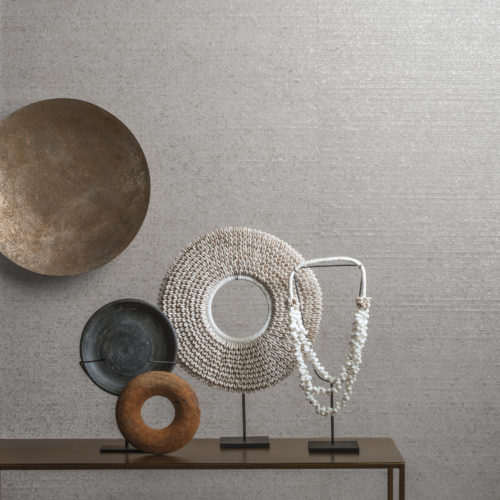 Console en métal avec œuvres d'art rondes. Sur le mur : Omexco Seraya. Bandes de capiz tissées : les coquillages capiz collectés sur les côtes des Philippines ornent nos murs de perles. La nacre est nettoyée, séchée, adoucie, colorée et polie, puis transformée en bandes tissées sur des métiers traditionnels pour un résultat époustouflant.