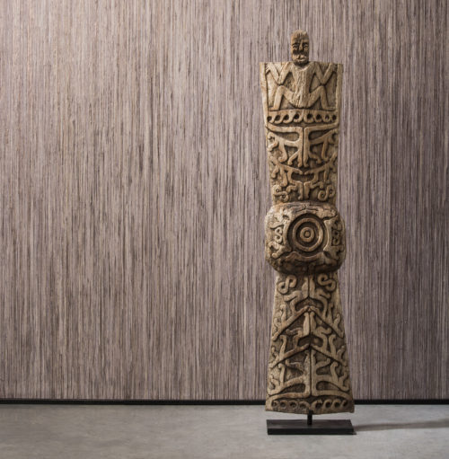 Détail du revêtement mural en raphia de Bornéo avec totem en bois. Le revêtement est posé verticalement.