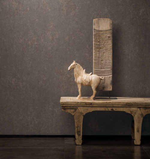 Décor chaleureux avec table en bois ethnique, œuvre d'art et cheval. Revêtement mural uni Bijou marron foncé sur le mur.