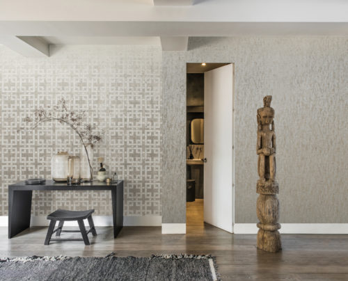 Chambre d'inspiration asiatique avec table noire et totem en bois. Porte donnant sur une petite salle de bains. Revêtement mural Kork sur les deux murs.