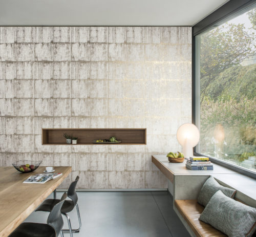 Pièce avec une grande fenêtre, des sièges sur le rebord de la fenêtre, un revêtement mural Antarès beige et blanc d'Omexco.