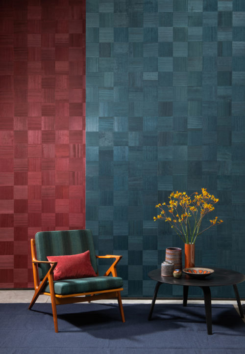 L'artisanat exquis crée des designs époustouflants. Chez Omexco, nous imaginons des formes et nous incrustons à la main chaque pièce de ce revêtement mural exclusif en sycomore. Ce détail d'intérieur montre le design élégant et intemporel du jeu d'échecs et un beau contraste entre le rouge et le vert.