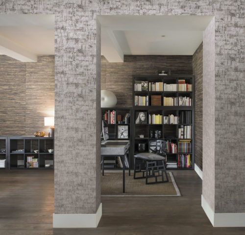 Bibliothèque de maison avec grande bibliothèque. Derrière elle, un revêtement mural nénuphar gris. Sur le mur menant à la pièce, un autre Omexco, uni cette fois.