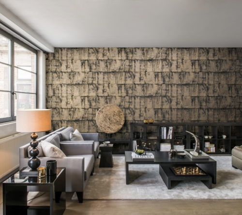 Salon contemporain. Sur le mur du fond : Antarès gris et or par Omexco wallcovering. Lampe sur pied et tables basses noires.