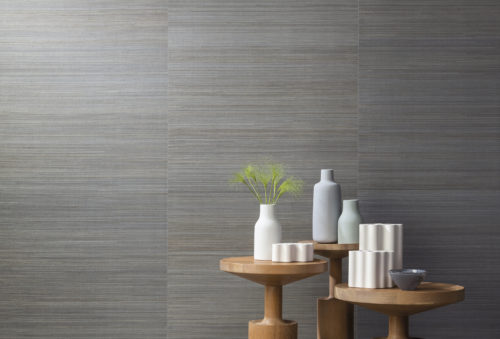 Sur cette photo, notre abaca très fin de la collection Seraya. Des fils d'abaca incroyablement fins tissés serrés pour un effet raffiné. Une version qui utilise des techniques modernes juxtaposées sur un support traditionnel. L'abaca gris est en contraste avec les vases pastel sur 3 tables rondes de différentes hauteurs.