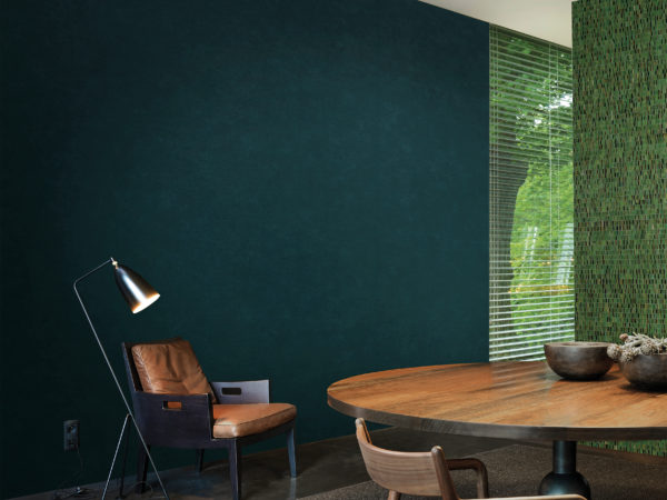 Salon avec fauteuil en cuir confortable et liseuse. Au mur, un revêtement mural Kaleidoscope d'un vert profond.