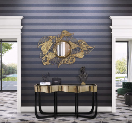 Couloir d'une maison avec piscine. Le revêtement mural Infinity à rayures bleu foncé et le miroir doré filigrané attirent l'attention.