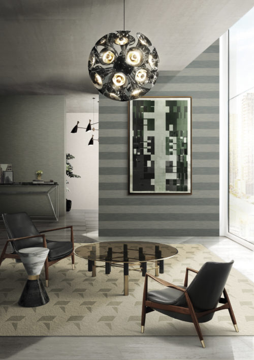Salon avec deux chaises en cuir autour d'une table centrale en verre foncé. Remarquable lampe suspendue chromée de Delightfull. Peinture abstraite. Revêtements muraux Infinity dans des tons gris.
