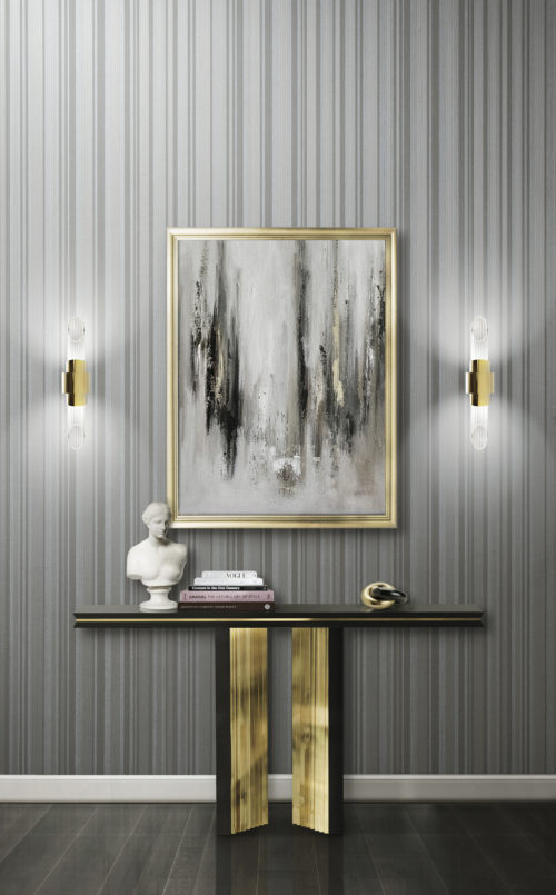 Impressionnante console dorée Beyond de Luxxu. Sur la console, un buste et quelques livres. Tableau brumeux. Les deux appliques Tycho font ressortir le revêtement mural Infinity.