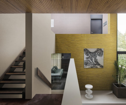Escalier dans une maison contemporaine. Revêtement mural Aruba jaune banane. Œuvre d'art en noir et blanc.