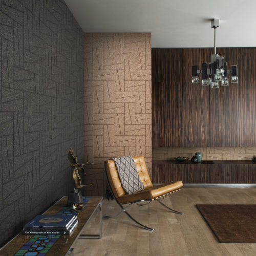 Sur les murs de ce salon moderne du milieu du siècle, nous voyons de petites pierres de mica saupoudrées sur un motif géométrique saisissant. Ce revêtement mural est appelé "stepping stone" et appartient à la collection Moonstone d'Omexco. La pièce maîtresse de ce salon est la chaise iconique Barcelona en cuir conçue par Mies van der Rohe.