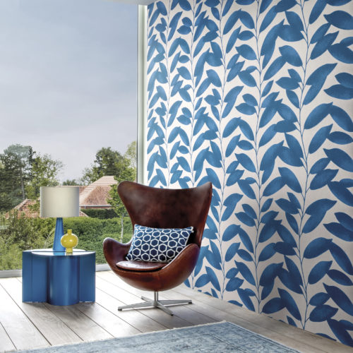Cette image montre le motif Blooming Marvellous de la collection de revêtements muraux Joy d'Omexco. Le design ludique avec un motif de feuilles bleues est la toile de fond parfaite pour l'emblématique fauteuil Egg conçu par Arne Jacobsen. La grande fenêtre apporte de la luminosité à cet espace contemporain.